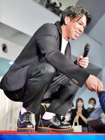 　小倉競輪のトークショーでファンに色紙を手渡した後に握手をする前田健太