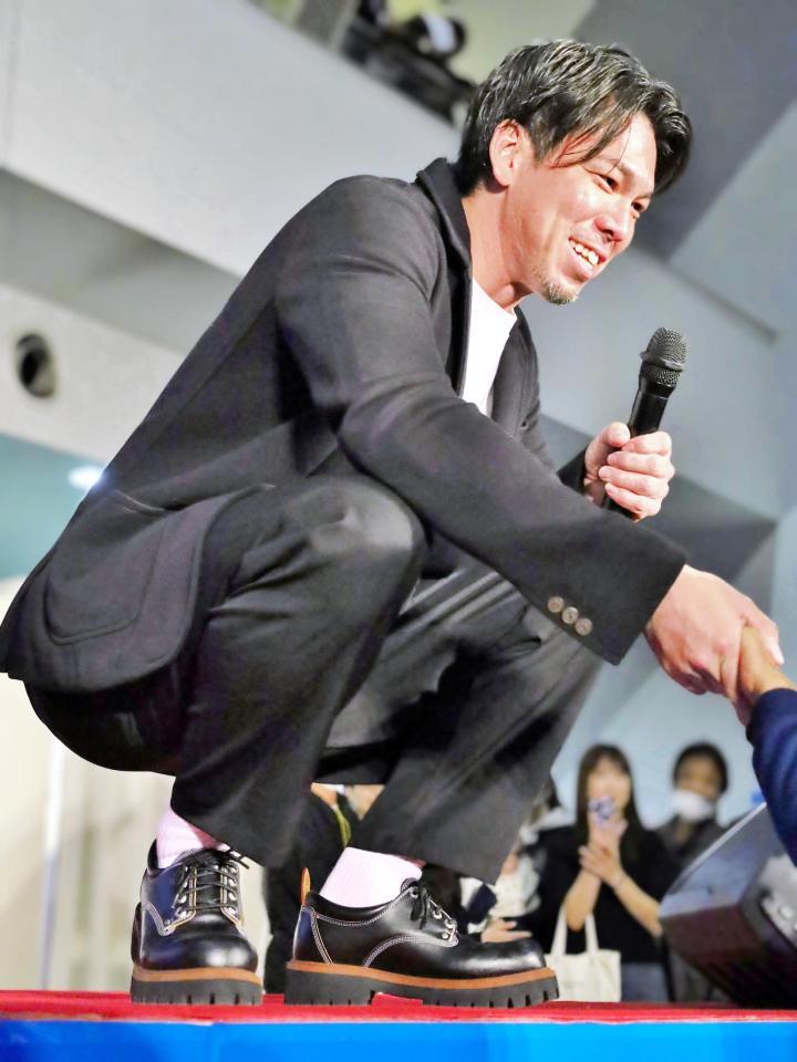 　小倉競輪のトークショーでファンに色紙を手渡した後に握手をする前田健太