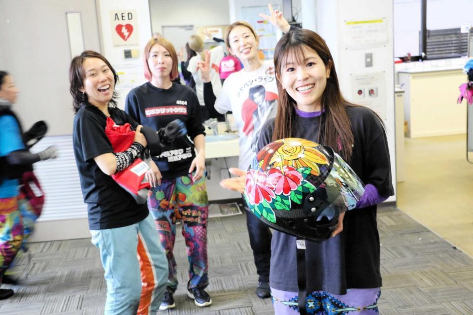 　自作の新デザインを手に笑顔の加藤奈月（後ろは左から今井、高田、原田）