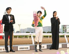 　ウシュバテソーロで東京大賞典を制し、表彰式で声援に応える横山和生騎手（中）。左はプレゼンターの志尊淳、右は菜々緒