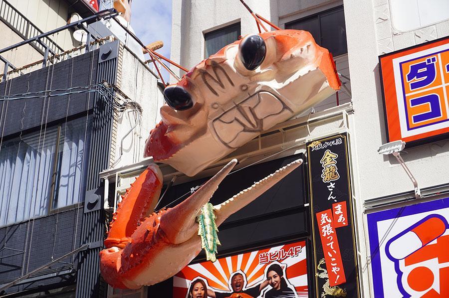 「金龍ラーメン」の立体看板・龍のしっぽを挟んだカニ（９月１７日撮影・大阪市内）