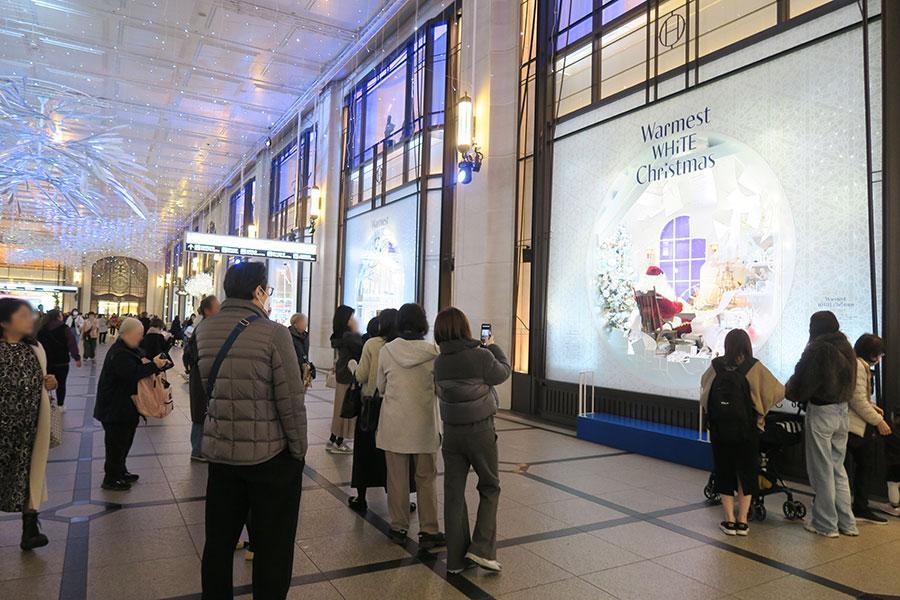 　「阪急うめだ本店」のコンコースウィンドーがクリスマス仕様に。思わず足を止め撮影を楽しむ人々（Ｌｍａｇａ.ｊｐ撮影）