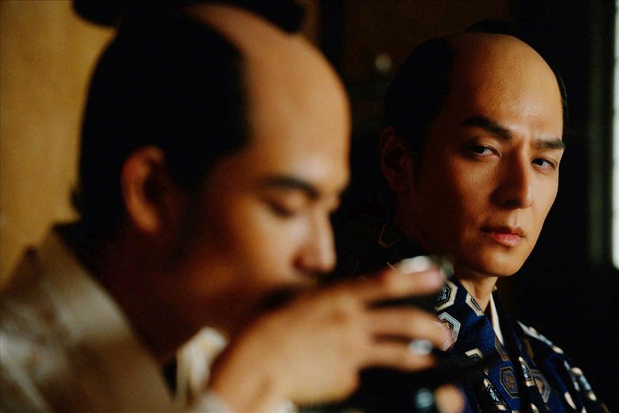 　『べらぼう～蔦重栄華乃夢噺～』第４７回より。１１代将軍・徳川家斉（写真左、城桧吏）がお茶を飲む様子を見る一橋治済（写真右、生田斗真）　©ＮＨＫ