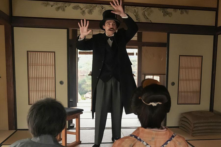 　『ばけばけ』第８１回より。モーニング姿で手品を見せるヘブン（トミー・バストウ）©ＮＨＫ