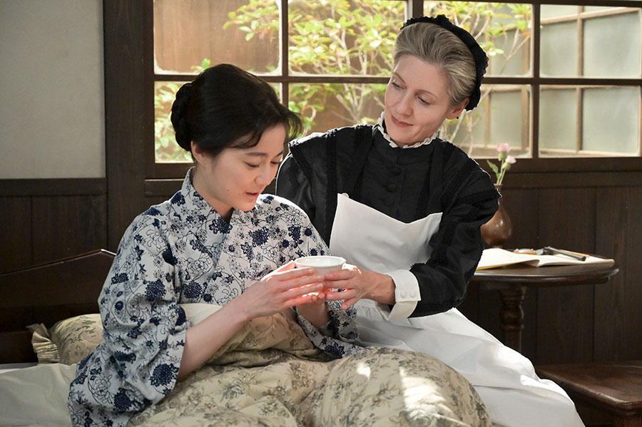 　『風、薫る』第３０回より。教師・バーンズ（写真右、エマ・ハワード）から水を飲ませてもらう多江（写真左、生田絵梨花）©ＮＨＫ