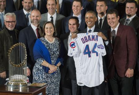 　１６日、贈呈されたユニホームを手に、ホワイトハウスを訪問した米大リーグ・カブスの選手らと記念撮影するオバマ大統領（ＵＰＩ＝共同）