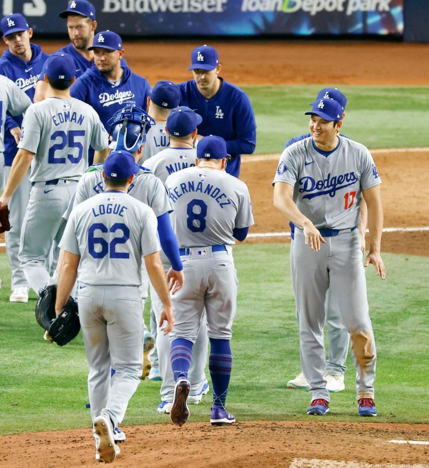 　マーリンズに大勝しタッチを交わす大谷（右端）ら。ドジャースは12年連続となるプレーオフ進出を決めた（共同）