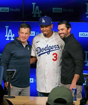 　ドジャースの入団会見に臨み、ユニホームを着用して笑顔のディアス（中央）。左はフリードマン編成本部長（共同）