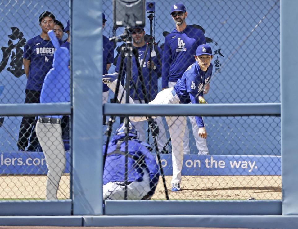 ブルペンで投球練習する佐々木（共同）