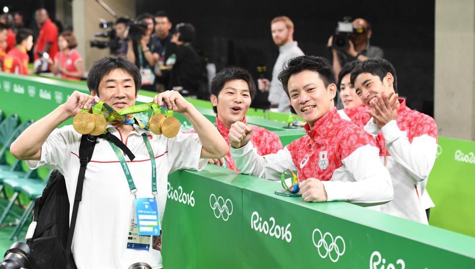 　森泉コーチに４つの金メダルをかけ喜ぶ（右から）白井健三、加藤凌平、田中佑典、山室光史