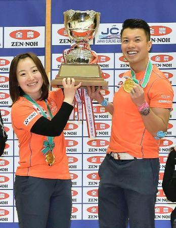 　カーリングの日本混合ダブルス選手権で優勝し、トロフィーを手に笑顔を見せる藤沢五月（左）と山口剛史のペア＝１８日、青森市のみちぎんドリームスタジアム
