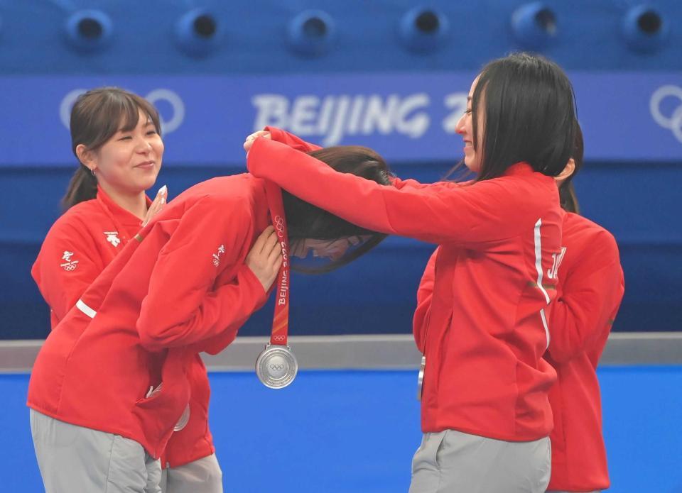 　石崎琴美（左手前）に銀メダルをかける藤沢五月（右手前）