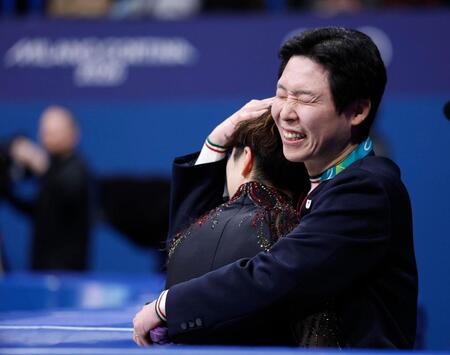 男子フリーの演技を終え、佐藤駿（左）を迎える日下匡力コーチ＝ミラノ（共同）