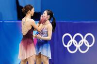 女子の表彰式を前に、坂本花織（左）に頰を挟まれる中井亜美＝ミラノ（共同）