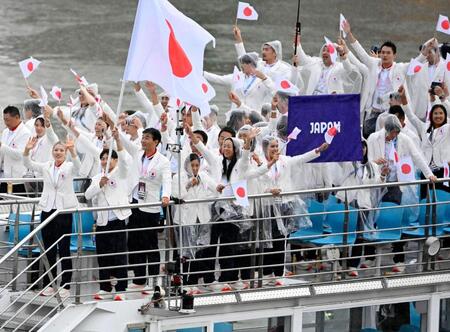 　パリ五輪の開会式で、セーヌ川を船でパレードする日本選手団。（手前左から）旗手の江村美咲、半井重幸（共同）