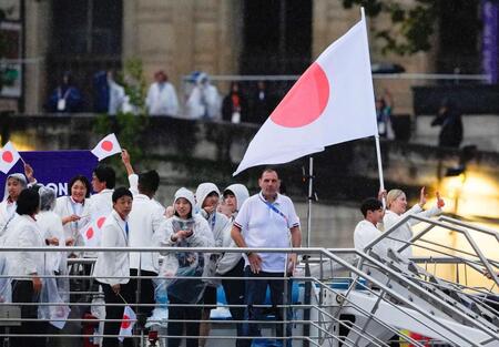 　パリ五輪の開会式で、セーヌ川をパレードする船上で手を振る日本選手団旗手の（右から）江村美咲、半井重幸（共同）