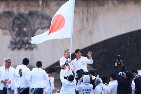 　パリ五輪の開会式で、セーヌ川をパレードする船上で手を振る日本選手団旗手の半井重幸（右）と江村美咲（代表撮影・共同）