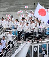 　セーヌ川で行われたパリ五輪の開会式で、船上で日の丸を掲げる旗手の半井重幸（中央右）と江村美咲（同左）ら日本選手団（共同）