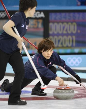 日本‐スイス 第6エンド、ショットを放つ小笠原。手前は苫米地=ソチ(共同)