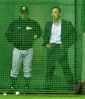 ネット越しに阪神・掛布ＤＣ（左）とともに打撃練習を見つめる金本知憲氏