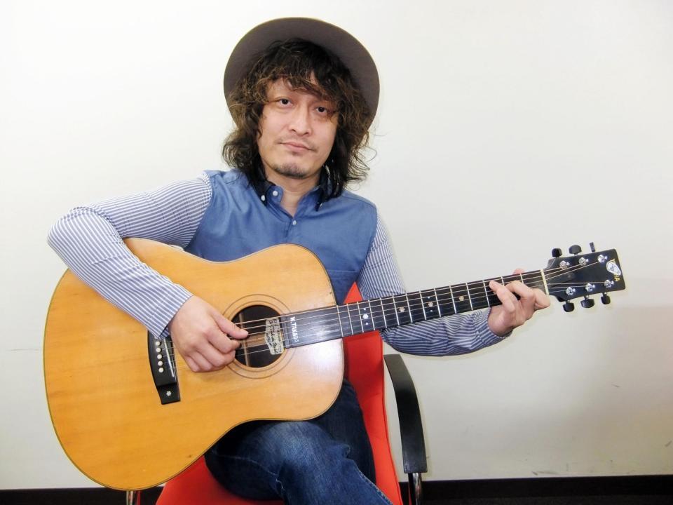 高田渡さんのギターをつま弾く高田漣＝都内のキングレコード