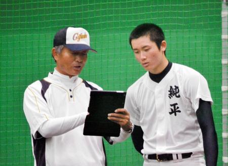 　タブレット端末を使って投球フォームを分析する県岐阜商・高橋純平投手(右）と太田郁夫コーチ