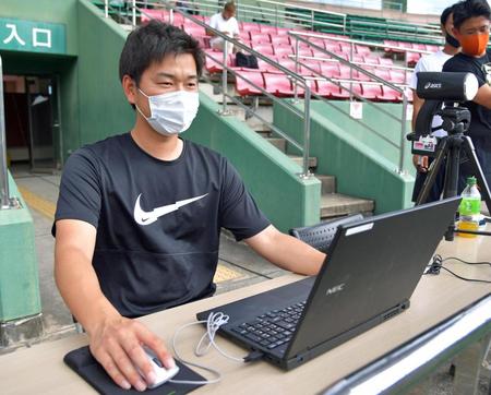 　ネット裏で試合を観戦し、データ収集をする飯田スコアラー＝天福球場