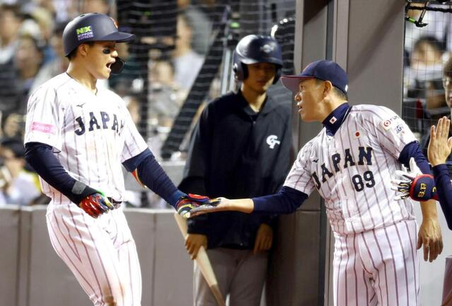 　韓国戦で２ランを放った森下（左）を迎える井端監督＝１５日