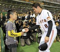　代打逆転満塁弾を放った巨人・谷佳知は試合後、木村拓也コーチの長男・恒希さん（左）にウイニングボールを手渡す＝２０１０年４月２４日
