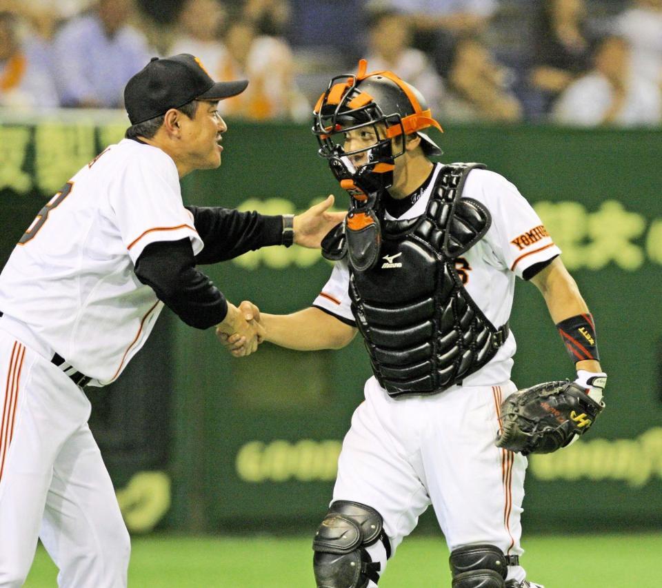 　延長十二回を無失点に切り抜けた捕手・木村拓也さんを迎える原監督＝２００９年９月４日