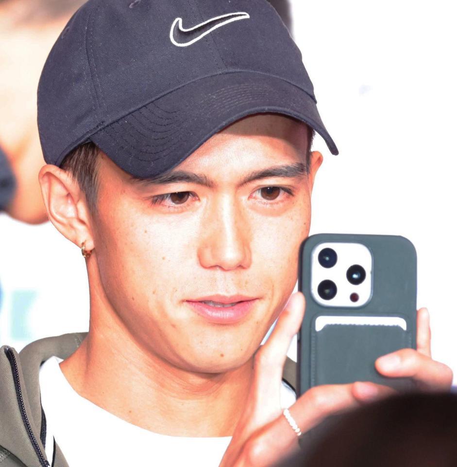 　会見中、報道陣をスマホで撮影する大迫傑（撮影・吉澤敬太）