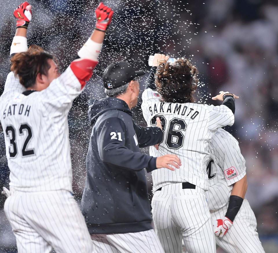 サヨナラ二塁打を放った安田尚憲（奥）にウオーターシャワーで祝福をするナインの輪の中へ飛び込むロッテ・吉井理人監督（２１）＝１６日、ＺＯＺＯマリン（撮影・開出牧）