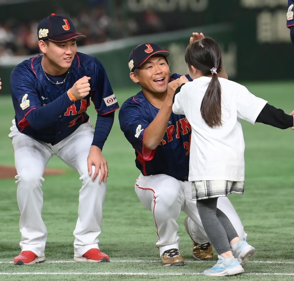 　日本対豪州の試合前セレモニーで女の子に笑顔を向ける田口（中央）と及川（撮影・伊藤笙子）