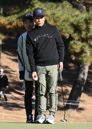 ３番、キャディーの妻・理乃さん（後方）と密着しながらラインを読む原敏之＝７日、東京よみうりＣＣ（撮影・開出牧）