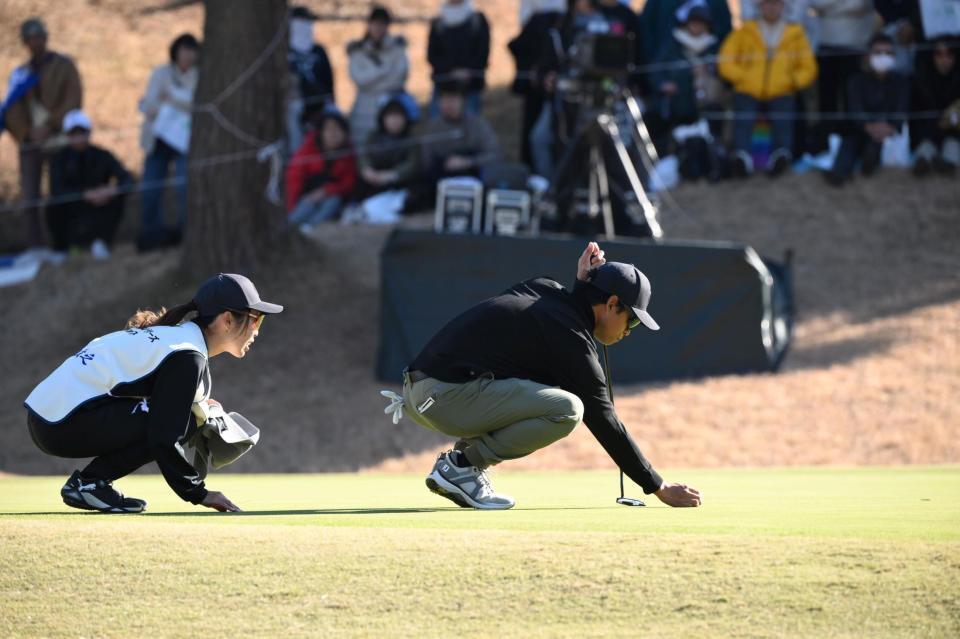 １８番グリーン、キャディーの妻・理乃さん（左）とラインを読む原敏之＝７日、東京よみうりＣＣ（撮影・開出牧）