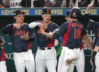 ２回、阪神・森下翔太、佐藤輝明にお茶たてポーズで迎えられるドジャース・大谷翔平（右）＝６日、東京ドーム（撮影・堀内翔）