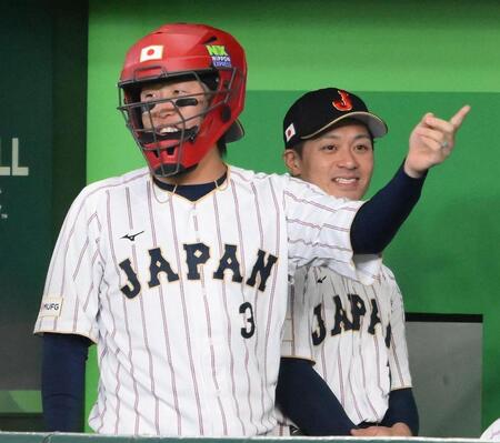試合前にキャッチャーマスクをかぶりグラウンドを指さす広島・小園海斗。後方は阪神・坂本誠志郎＝８日（撮影・堀内翔）