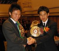 先輩の五十嵐俊幸(左)と握手を交わす井岡一翔