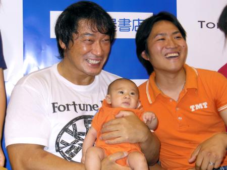 　ファンの赤ちゃんを抱く小橋建太氏（左）