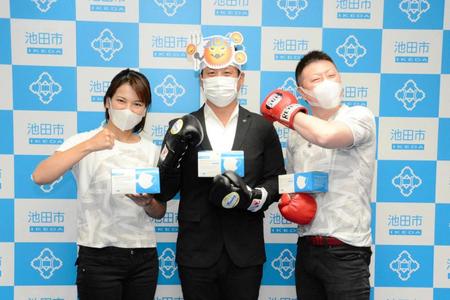 池田市にマスク１万枚を寄贈した野上真司オーナー（右端）と妻の野上奈々会長（左端）中央は冨田裕樹池田市長