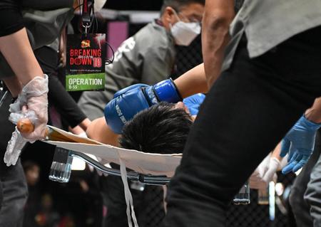 　担架で運ばれる才賀紀左衛門＝１１月２３日