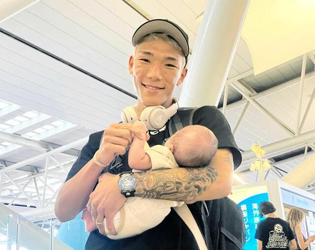 　息子を抱きながら笑顔を見せる亀田京之介（撮影・中谷大志）