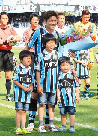 　試合前のセレモニーで、息子３人から花束を贈られ笑顔の川崎・大久保。Ｊ１通算３５０試合出場を達成した（共同）