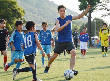 　ロアッソ熊本と地元小学生たちとの交流会で、サッカーをする長友佑都選手＝２３日午後、熊本市