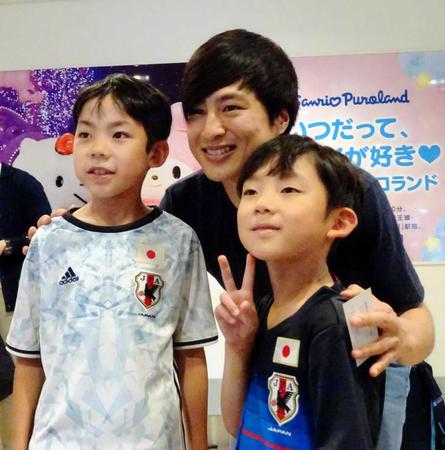 　日本代表に初選出されて帰国した加藤（中央）は少年ファンに写真を求められて笑顔