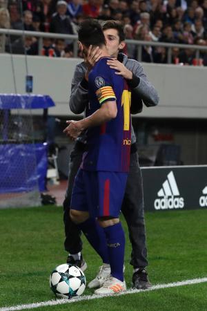 　１０月３１日、ギリシャでの欧州ＣＬの試合中、バルセロナのメッシに抱きつきキスをする男性（ＡＰ＝共同）