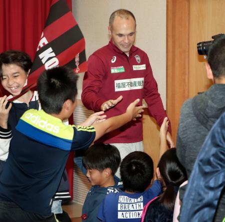 　神戸市立だいち小を訪れ、児童とタッチを交わすイニエスタ選手＝１７日