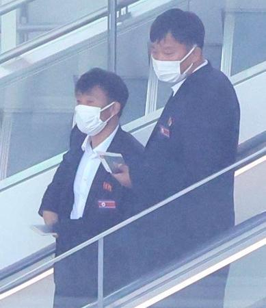 　国旗を胸につけて中国行きの飛行機に乗り込む北朝鮮代表関係者ら（撮影・吉澤敬太）