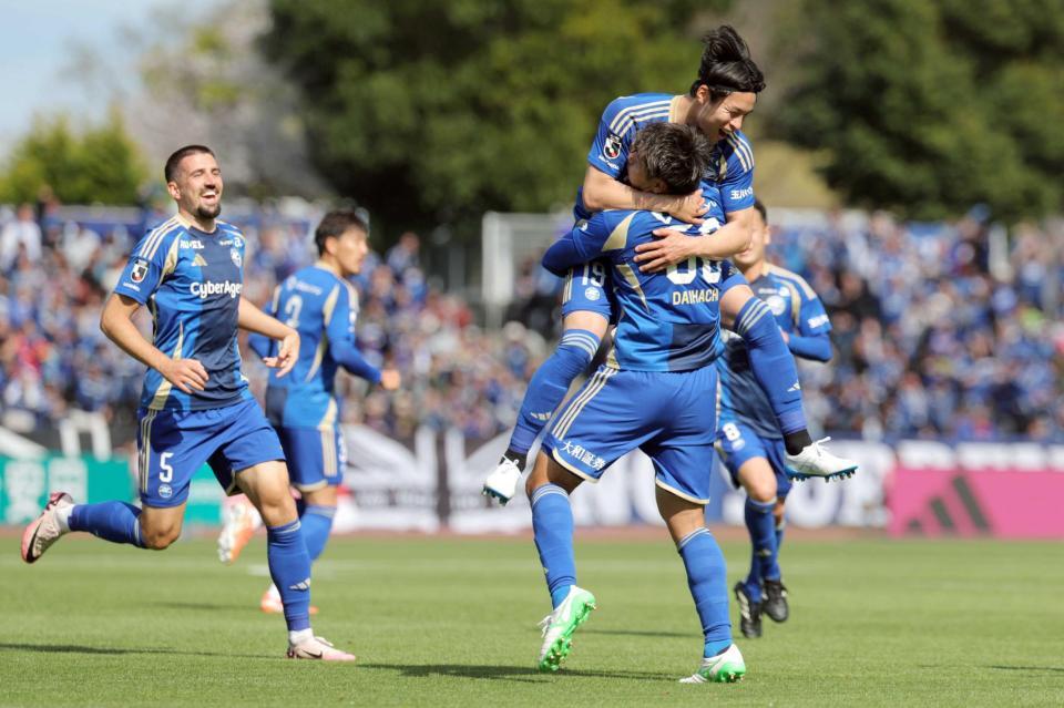 　前半、同点ゴールを決め、中山（右上）に抱きつかれて祝福される町田・岡村