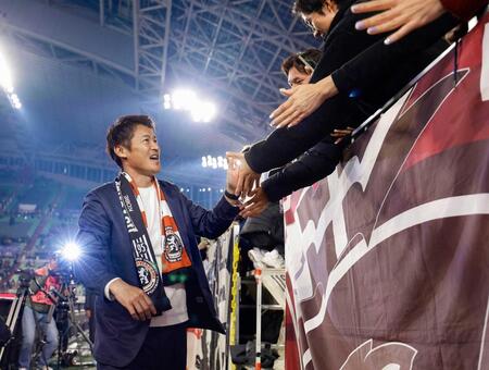 　今季限りでの退任を発表後、サポーターとタッチを交わす神戸・吉田監督